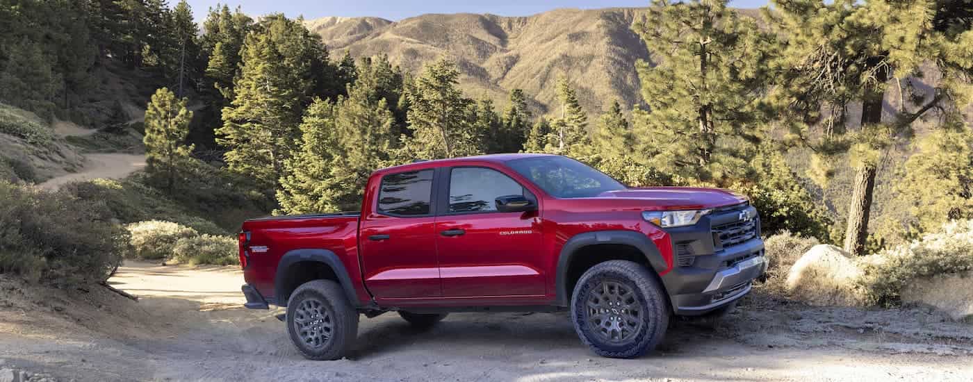 A red 2024 Chevy Colorado Trail Boss is shown from the side while off-road after leaving a Chevy dealer near Ypsilanti.