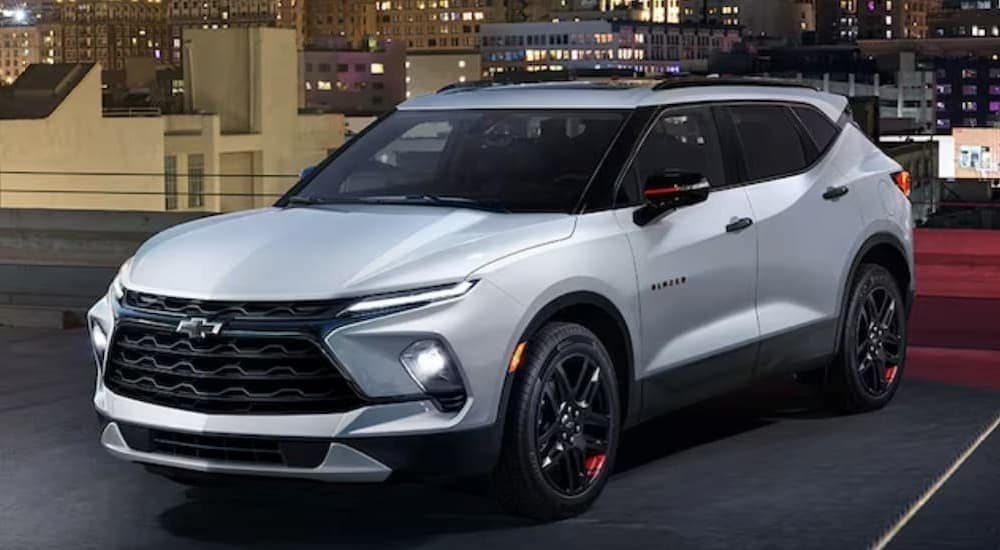 A white 2024 Chevy Blazer is shown parked in a garage after visiting a Chevy dealer near Brighton.