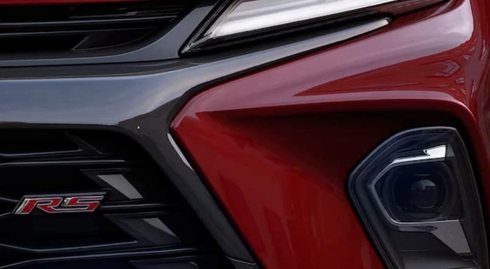 A close-up on the headlight of a red 2024 Chevy Blazer RS.