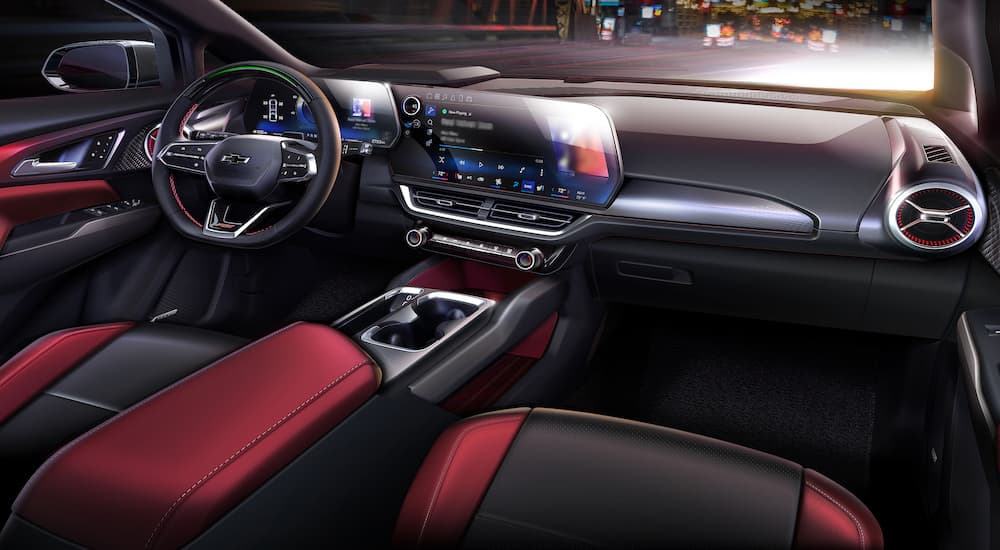 The red interior of a 2024 Chevy Equinox EV is shown from the passenger seat.