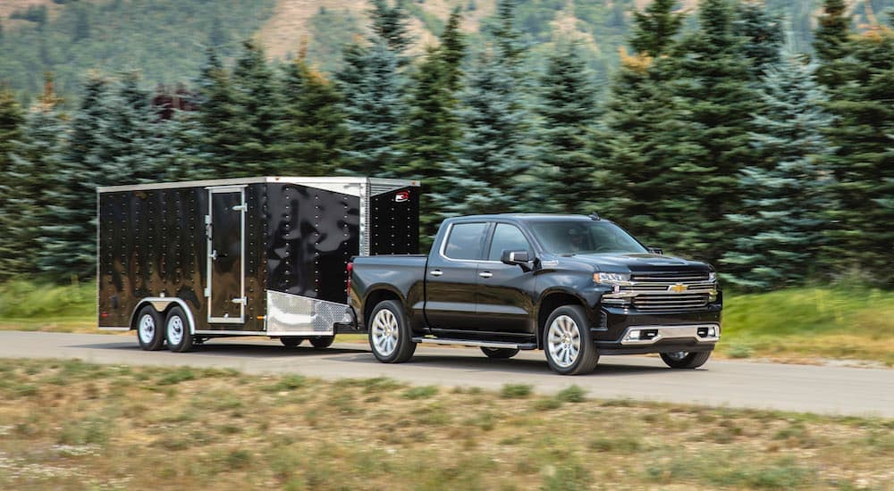 A black 2020 Chevy Silverado 1500 towing a trailer.