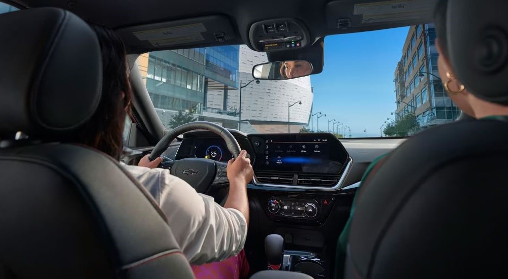 Two people driving in a 2024 Chevy Trax