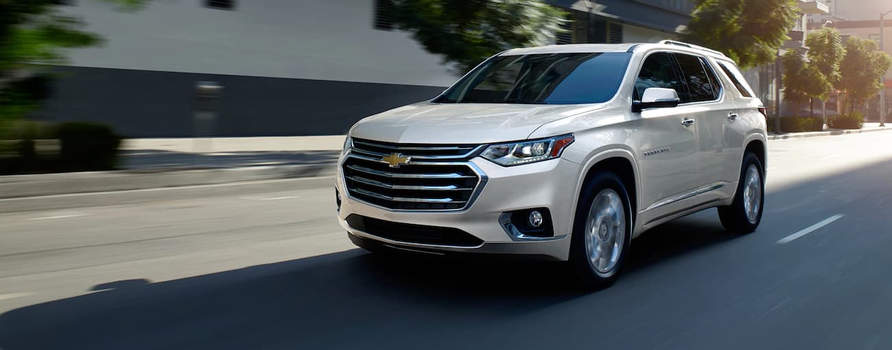 White 2020 Chevy Traverse High Country driving down a road.