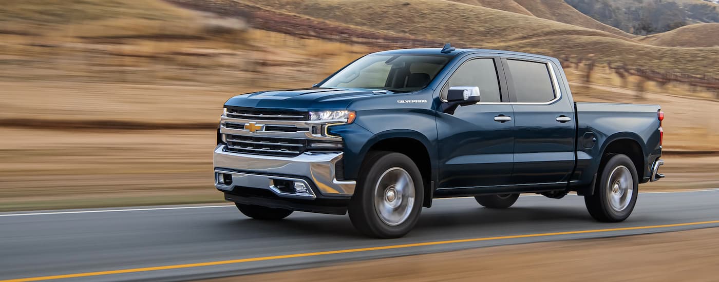 Blue 2021 Chevy Silverado 1500 driving on an open road