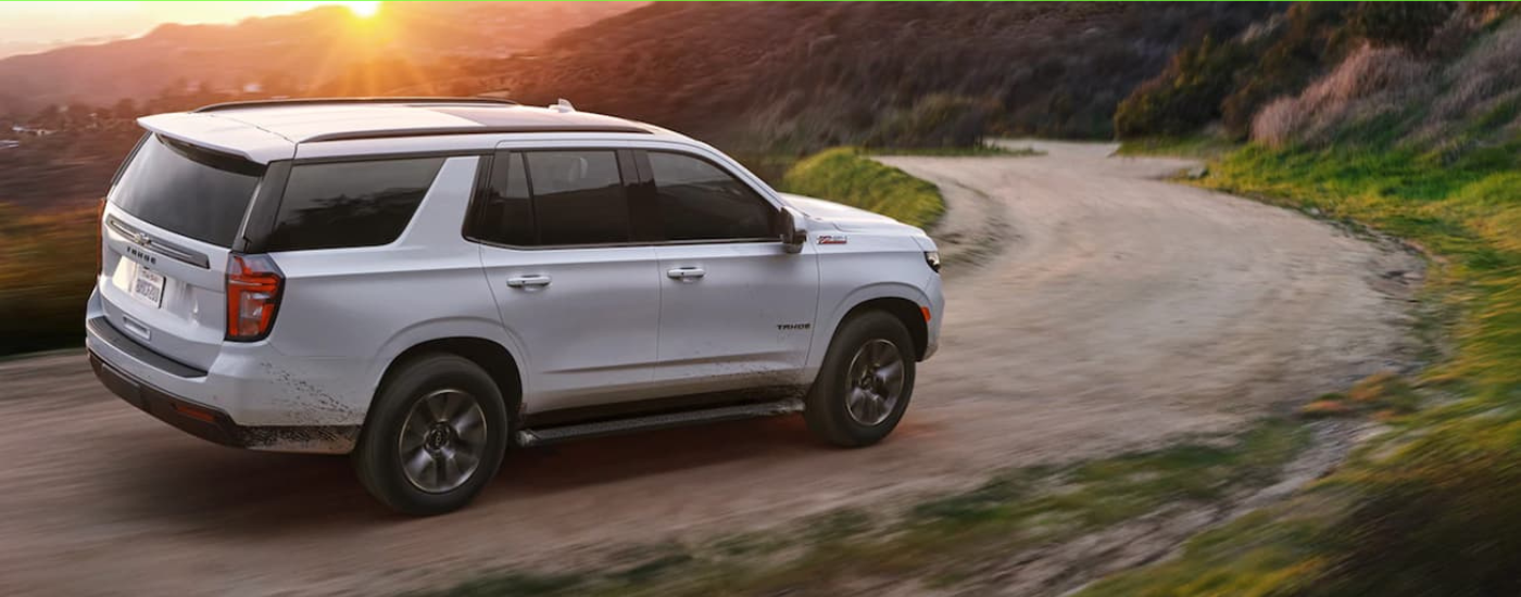 White 2021 Chevy Tahoe driving down a trail
