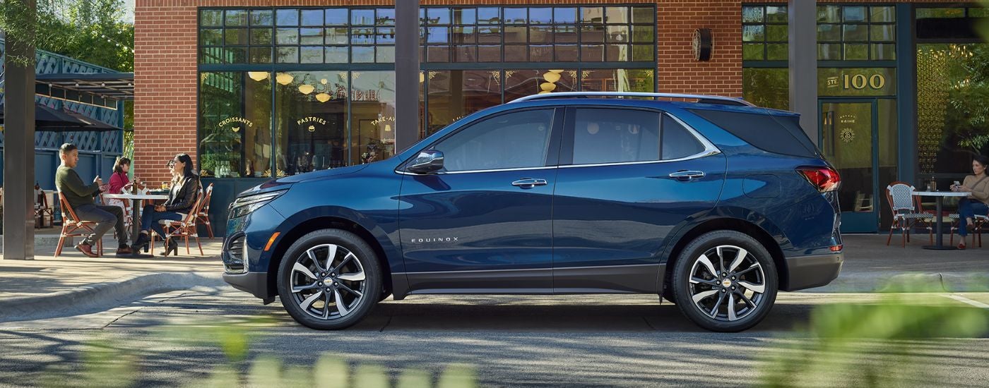 Blue 2022 Chevy Equinox parked on a street in front of a cafe.