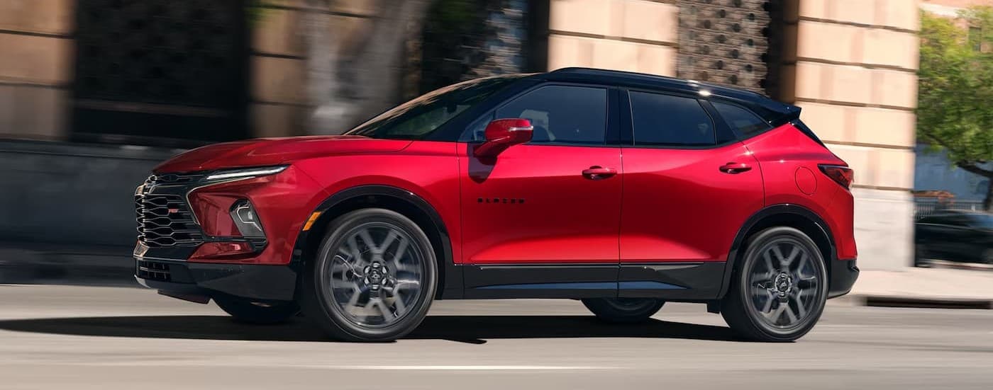 A red 2025 Chevy Blazer RS drivig in a city.