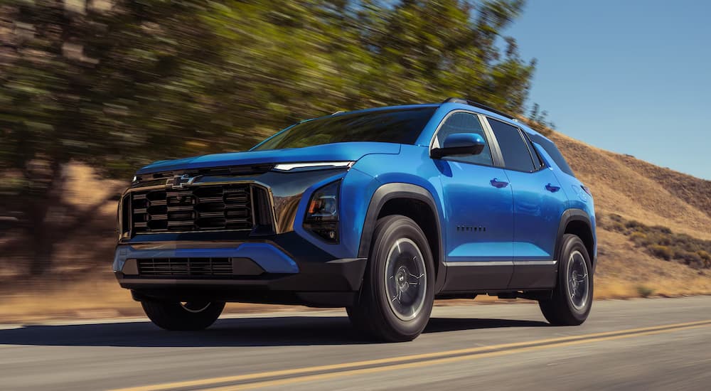 Blue 2027 Chevy Equinox driving down an open road.