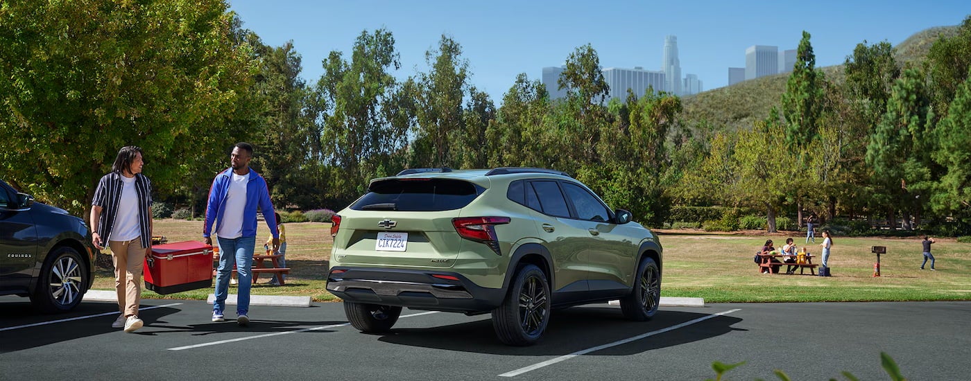 Rear view of a green 2025 Chevy Trax ACTIV parked in a parking spot.