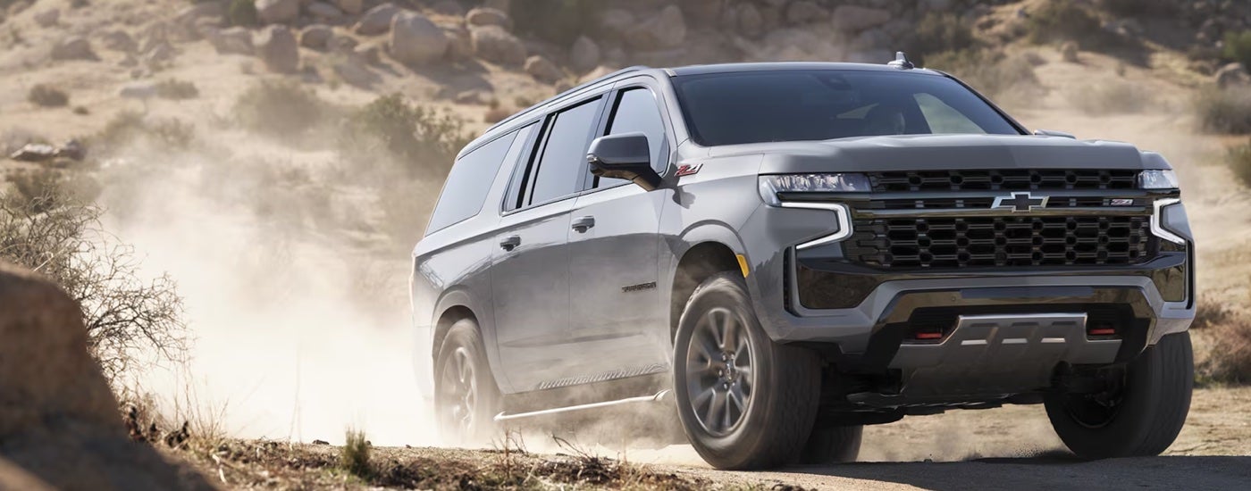A grey 2024 Chevy Suburban Z71 kicking up dust while off-roading.