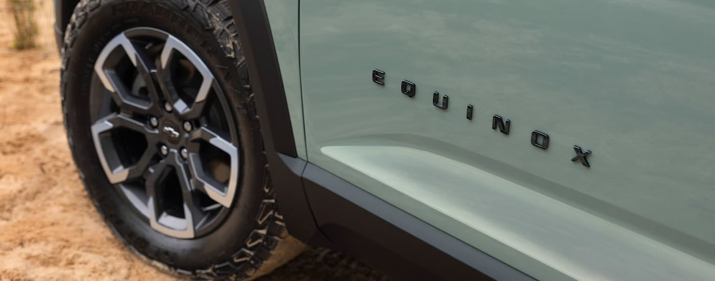 A close-up on the wheel of green 2025 Chevy Equinox for sale near Brighton.