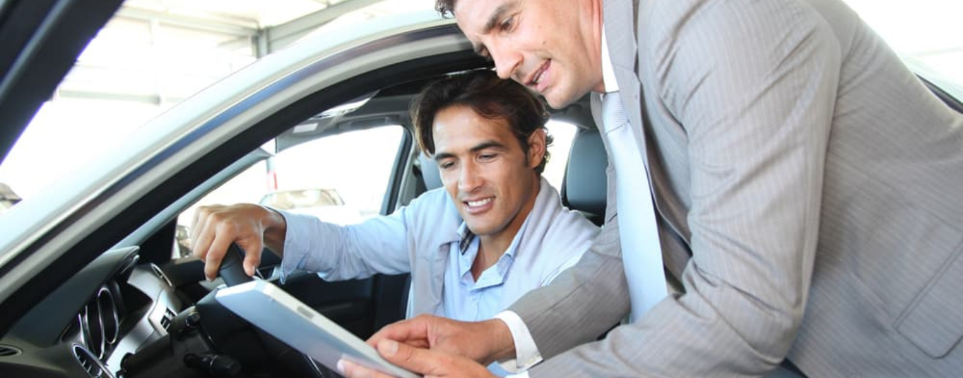 A man talking to a car salesman