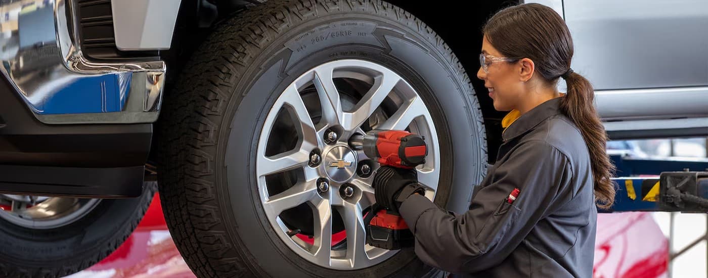 A technician tightening the lugnuts on a tire.